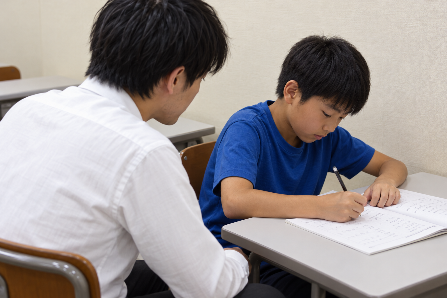 先生がそばで見守る小学生の学習イメージ
